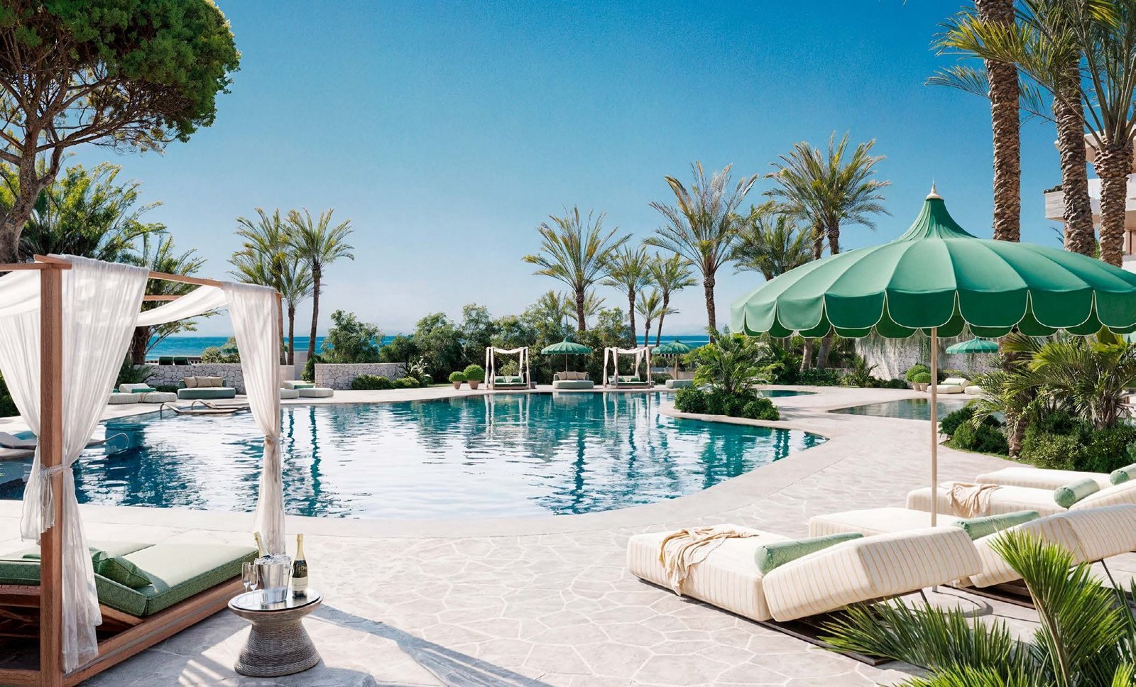 Communal swimming pool with shaded cabanas and palm trees at SB by the Sea, Estepona